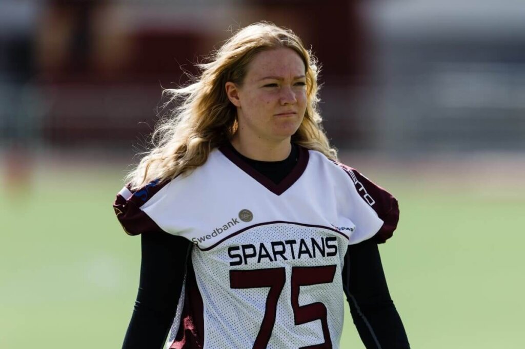 Blonde woman wearing white maroon Spartans football jersey