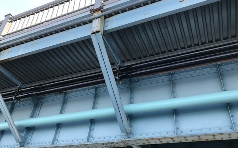 Exposed conduit running a long a bridge